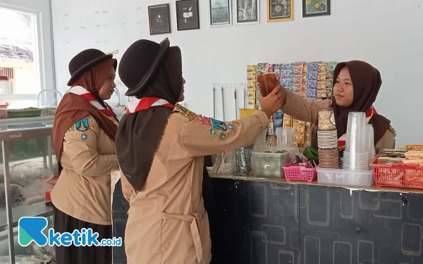 Foto Siswi SMAN Pilangkenceng sedang melayani pembeli Cafe Mart SMAPI  (Foto: Fatimah/Ketik.co.id)