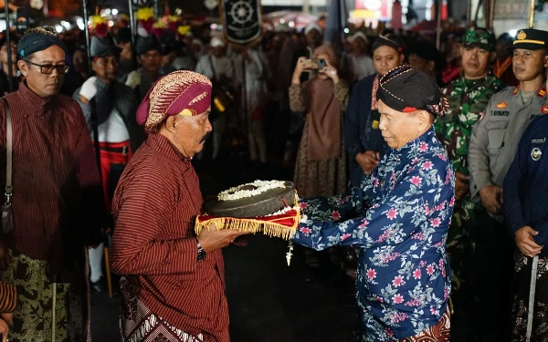 Foto Serah terima pusaka, kitab dan bendhe oleh Lurah Banyuraden Sudarisman (kanan) kepada perwakilan keluarga keturunan Ki Demang Cokrodikromo. (Foto: Humas Pemkab Sleman/Ketik.co.id)