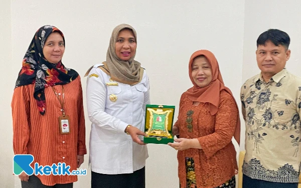 Foto Pj Bupati Fitriany Farhas menyerahkan cinderamata berbentuk 'Pintoe Aceh' kepada Plt Deputi Bidang Kesetaraan Gender Kementerian PPPA Eini Handayani di Jakarta, Rabu (24/7/2024). (Cutbang Ampon/Ketik.co.id)