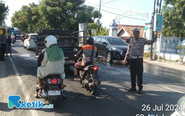 Foto Polisi saat mengatur lalin di lokasi truk bermuatan garam yang mengalami laka tunggal (Foto: Mat Jusi/Ketik.co.id).