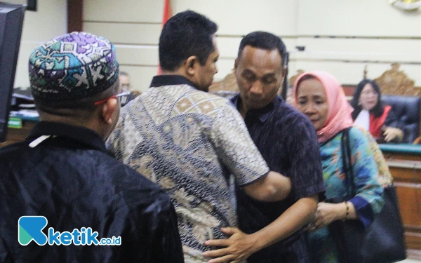 Foto Mantan Kepala BPPD Sidoarjo Ari Suryono (pakai batik) berpelukan dengan Setya Handaka, Kabid di BPPD Sidoarjo, di Pengadilan Tipikor pada Senin (22/7/2024). (Foto: Fathur Roziq/Ketik.co.id)