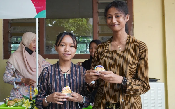 Foto Dua siswi Smansaba Situbondo memamerkan kue cromboloni karya Program Double Track. (Foto: Akhirul Ariyanto/Smansaba)