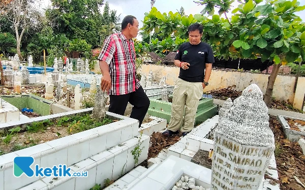 Foto Tommy (kanan) ditemani Syukur penjaga Pemakaman Muslim Paindoan Rantauprapat saat meninjau tanda pejuang yang telah berhilangan. (Foto: Joko/Ketik.co.id)