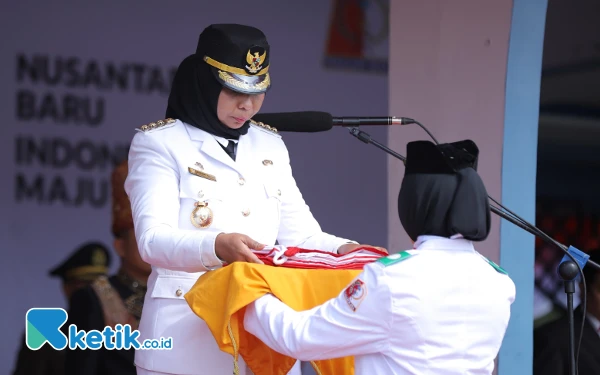 Foto Pj Bupati Nagan Raya Fitriany Farhas menyerahkan bendera Merah Putih kepada petugas pengibar bendera dalam HUT ke-79 RI di Alun-alun Suka Makmue, Sabtu (17/8/2024). (Foto: Cutbang Ampon/Ketik.co.id)