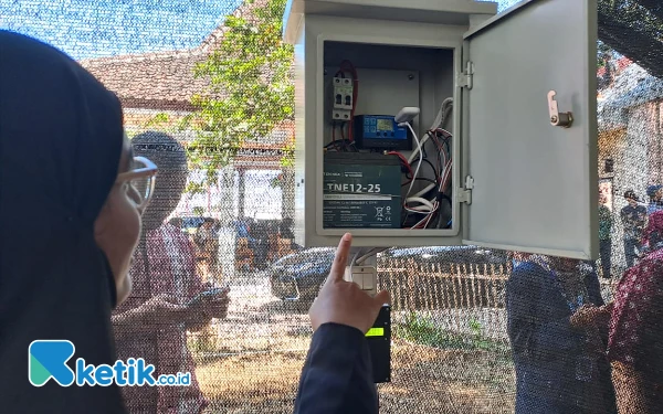 Foto Seorang mahasiswi menunjukkan instalasi pembangkit listrik tenaga surya (Foto: Fenna/Ketik.co.id)