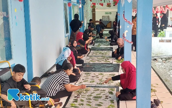 Foto Puluhan siswa SLB YPAC Surabaya dibantu orang tua dan guru terlihat bersemangat membuat batik ecoprint. (Foto: Husni Habib/Ketik.co.id)