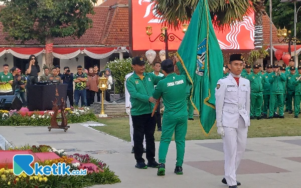 Foto Pj Gubernur Jatim Adhy Karyono memberikan pataka Jawa Timur ke Komandan kontingen M Nabil sebagai pertanda pelepasan atlet, Jumat, 30 Agustus 2024. (Foto: Khaesar/Ketik.co.id)