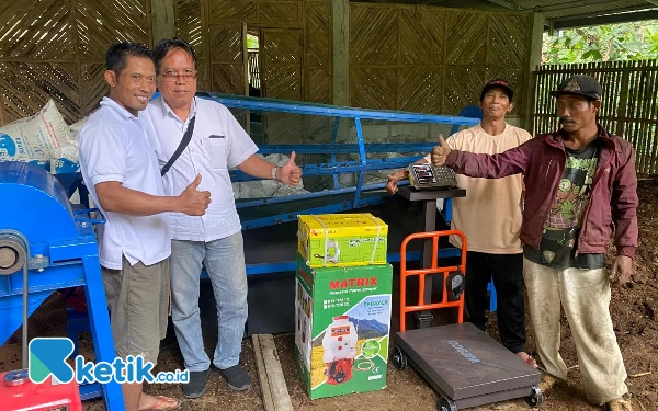 Foto Petani Kopi bersama Tim Pengmas UB menunjukkan mesin produksi pupuk organik.