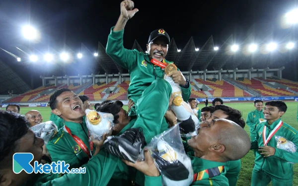 Foto Pemain sepak bola putra Jatim mengangkat coach Fakhri Husaini usai meraih medali emas, Rabu, 18 September 2024. (Foto: Khaesar/Ketik.co.id)