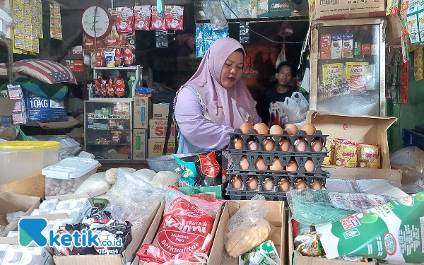 Foto Salah satu pedagang pasar Dukuh Kupang, Nibras saat ditemui di kiosnya. (Foto: Husni Habib/Ketik.co.id)