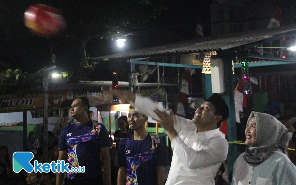 Foto Calon Bupati Sidoarjo Subandi memukul bola service pertama sebelum laga final turnamen bola voli bal plastik. (Foto: Fathur Roziq/Ketik.co.id)