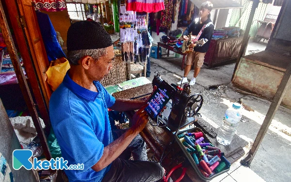 Foto Seorang penjahit mengakses sebuah portal edukasi “Bersama Stop Judi Online” di Pasar Wirosari, Kabupaten Grobogan, Jawa Tengah, pada Ahad, 13 Oktober 2024. Portal yang berisi informasi tentang bahaya judi online tersebut diluncurkan oleh Kementerian Komunikasi dan Informatika (Kominfo) RI sebagai salah satu langkah strategis untuk memberantas perjudian online di Indonesia. (Foto: Achmad Fazeri/Ketik.co.id)