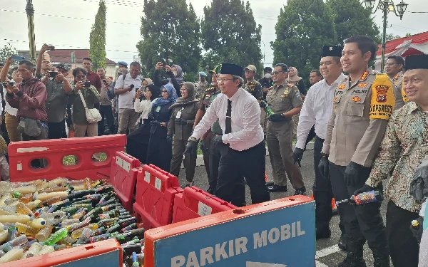 Foto Pjs Bupati Sleman Kusno Wibowo (berdasi) beserta unsur Forkopimda Kabupaten Sleman menghadiri proses penindakan pemusnahan barang bukti miras. (Foto: Oliv/Ketik.co.id)