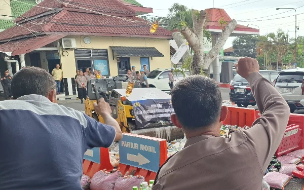 Foto Selanjutnya barang bukti miras dimusnahkan dengan mesin penggilas. (Foto: Oliv/Ketik.co.id)