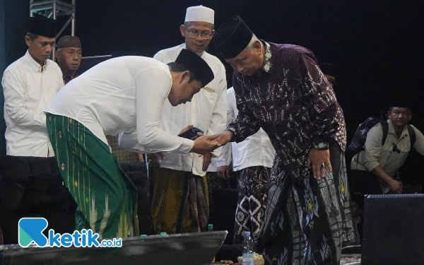 Foto Subandi menyalami KH Nurkholis Misbah setelah selesai acara Peringatan Satu Abad Ponpes Ploso dan Hari Santri 2024 pada Selasa malam (22 Oktober 2024) di parkir timur GOR Delta. (Foto: Istimewa)