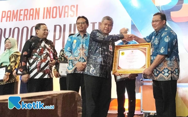 Foto Sekda, Heru Wiwoho (kiri piagam) dan dr. Iman Darmawan (kanan) saat simbolis penyerahan Piagam Penghargaan dari Kementerian Pendayagunaan Aparatur Negara dan Reformasi Birokrasi melalui Pemkab. (Foto: Al Ahmadi/Ketik.co.id)