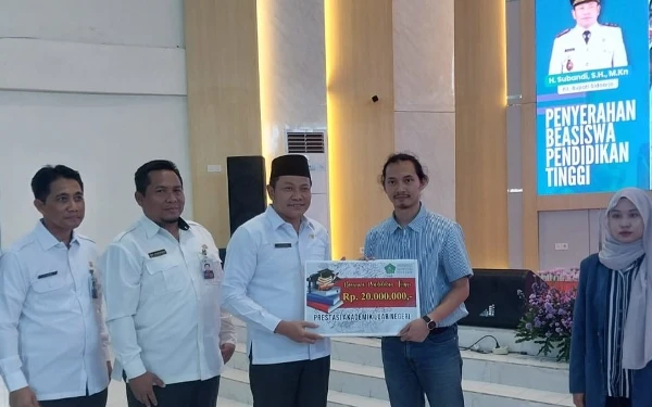 Foto Calon Bupati Sidoarjo Subandi saat menjabat Plt Bupati Sidoarjo menyerahkan beasiswa pendidikan kepada mahasiswa. (Foto: Dinas Kominfo)