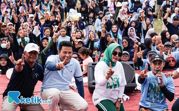 Foto Calon Bupati Sidoarjo Subandi dan calon Wakil Bupati Sidoarjo Mimik Idayana foto bersama ribuan peserta senam di Lapangan Desa Pangreh, Jabon. (Foto: Dimas for Ketik.co.id)