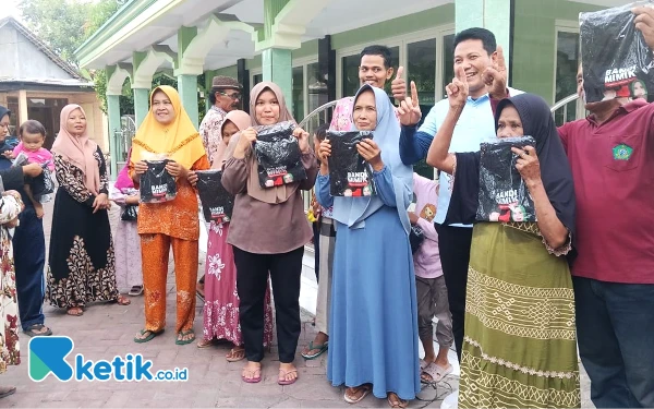 Foto Calon Bupati Sidoarjo Subandi melayani permintaan foto bersama warga yang senang karena diberi kaos bergambar Pasangan BAIK. (Foto: Dimas for Ketik.co.id)