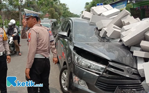 Foto Potret Toyota Kijang Innova yang menyungsep di tumpukan batako depan kios bensin di tepi Jalan Tentara Pelajar, Dusun Krajan, Desa Widoro, Kecamatan Pacitan, Rabu, 13 November 2024. Polisi lakukan cek TKP dan siaga mengatur lalulintas. (Foto: Polres Pacitan for Ketik.co.id)