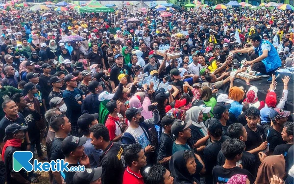 Foto Calon Bupati Sidoarjo Subandi duduk untuk menyapa ramah dan memberikan minuman serta kaus untuk ribuan penonton di Lapangan Desa Tlasih. (Foto: Dimas for Ketik.co.id)