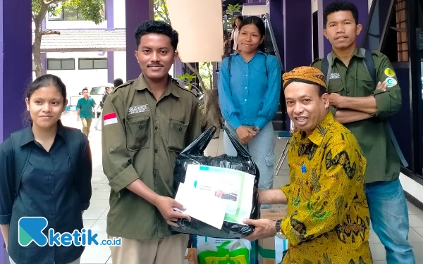 Foto Ketua Penyelenggara Penggalangan Bantuan Kemanusiaan Unitri Malang Agustinus Ghunu menerima sumbangan dari perwakilan mahasiswa. (Foto: Unitri Malang)