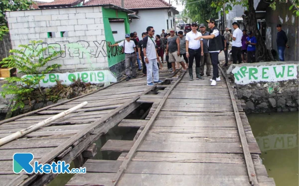 Foto Plt Bupati Sidoarjo Subandi dan Kepala Dinas PU Bina Marga dan SDA Sidoarjo Dwi Eko Saptono berdiskusi di sisi jembatan kayu Desa Kedungpeluk. (Foto: Fathur Roziq/Ketik.co.id)