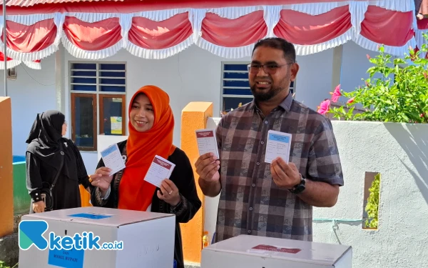 Foto Bupati Bassam dan Isteri ketika memasukan surat suara ke kotak suara. (Foto Mursal Bahtiar)