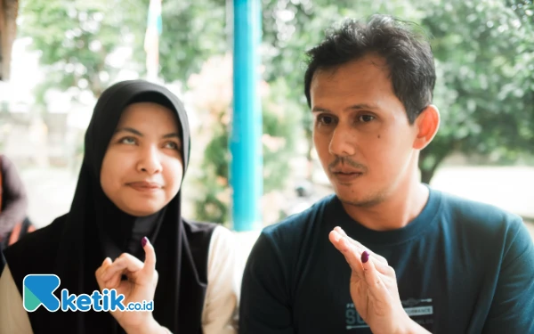 Foto Pasangan suami istri penyandang tuna netra di Kota Palembang, Susilo dan Riska berpose dengan menunjukkan tinta tanda telah melakukan pencoblosan, Rabu 27 November 2024. Keduanya merupakan atlet goalball yang sudah mengharumkan nama Sumatera Selatan di kancah olahraga nasional. (Foto: Wisnu Akbar Prabowo/Ketik.co.id)