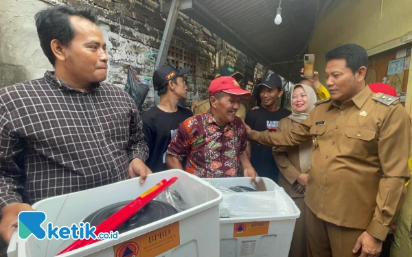 Foto Plt Bupati Sidoarjo Subandi menyerahkan bantuan untuk Rudi yang rumahnya terbakar di Desa Banjarkemantren, Kecamatan Buduran, pada Senin (2 Desember 2024). (Foto: Dinas Kominfo Sidoarjo)