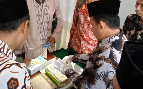 Foto Kang oman saat melihat manuskrip Sampurnan peninggalan muasis. (Foto:Istimewa)