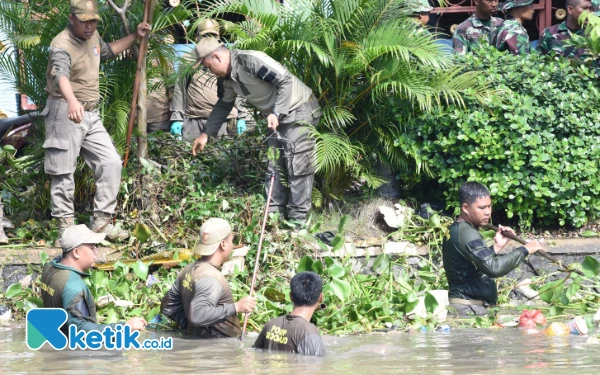 Foto Anggota Satpol PP Sidoarjo turun ke sungai demi membersihkan Kali Pelayaran agar tidak meluap dan memicu banjir. (Foto: Sigit Kominfo Sidoarjo)