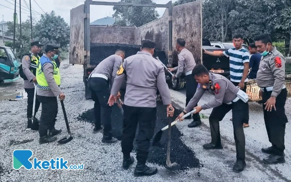 Foto Personel Satlantas Polres Labuhanbatu menimbun lubang di jalinsum Kelurahan Bandar Durian, Aek Natas, Labura. (Satlantas Polres Labuhanbatu for Ketik.co.id)