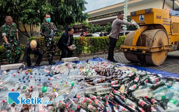 Foto Pemusnahan barang bukti miras dilakukan dengan alat berat slender hingga hancur bersama botol-botolnya. (Foto: Dimas Maulana/Ketik.co.id)