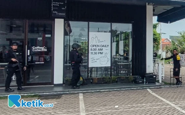 Foto Petugas bersenjata mengamankan area sekitar kafe tempat ditemukannya koper hitam di SPBU Jalan Arteri, Porong, pada Kamis (2 Januari 2025). (Foto: Dimas Maulana/Ketik.co.id)