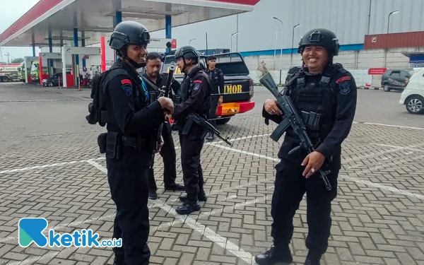 Foto Anggota Satbrimob Polda Jatim menjaga kawasan sekitar Pom Bensin Jalan Arteri Porong untuk memastikan kondisi aman. (Foto: Dimas Maulana/Ketik.co.id)