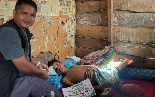 Foto Ustadz Asmar Habibi menyerahkan donasi bagi pengobatan kaum duafa. (Foto: Yumasa Humanity)