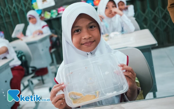 Foto Salah satu siswa SD Negeri 25 Kota Palembang, Queenza Elena (8) menunjukkan kotak makanannya yang sudah habis, Senin 6 Januari 2025.