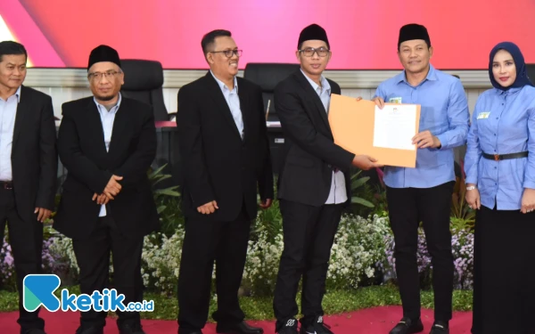 Foto Ketua KPU Sidoarjo Fauzan Adhim bersama para komisioner KPU Sidoarjo menyerahkan surat penetapan calon bupati terpilih kepada Subandi dan Mimik Idayana. (Foto: Kominfo Sidoarjo)