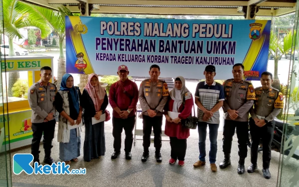 Foto Kapolres Malang AKBP Danang Setiyo Pambudi Sukarno ketika berfoto bersama Keluarga korban Tragedi Kanjuruhan yang menerima bantuan. (Foto: Binar Gumilang/Ketik.co.id)