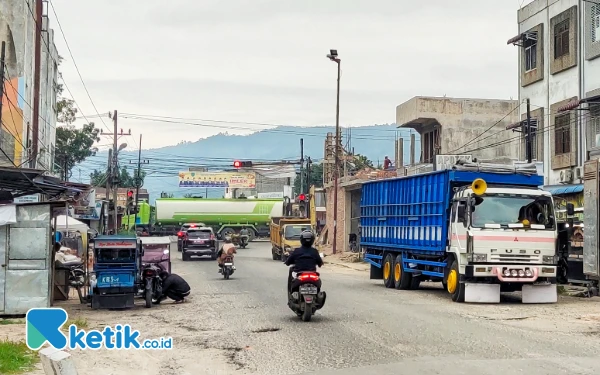 Foto Truk roda 10 (kanan) masih terlihat parkir di Jalan Sirandorung Rantauprapat, Labuhanbatu, padahal Perda larangan telah disahkan. (Foto: Joko/Ketik.co.id)