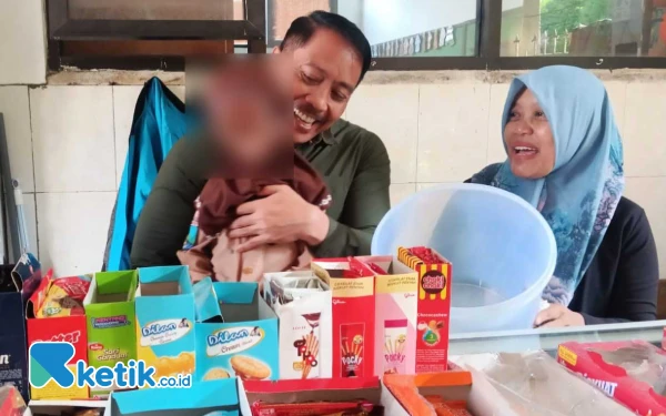 Foto Ketua Komisi D DPRD Sidoarjo Dhamroni Chudlori mengajak Arla dan menggendongnya saat jajan di kantin sekolah ditemani Mei Rista. (Foto: Fathur Roziq/Ketik.co.id)