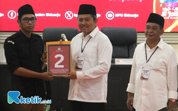 Foto Pasangan SAE (Mas Iin-Abah Edi) menerima nomor urut calon bupati dan calon wakil bupati peserta Pilkada Sidoarjo 2024 dari Ketua KPU Sidoarjo Fauzan Adhim pada Senin (23/9/2024). (Foto: Fathur Roziq/Ketik.co.id)