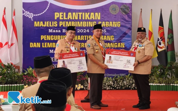 Foto Pj Wali Kota Madiun sebagai Kamabicab dan Suyoto Ketua Kwarcab Kota Madiun menerima kartu tanda anggota Pramuka oleh Arum Sabil Ketua Kwarda Jatim. (Foto: Naufal/Ketik.co.id)