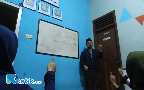 Thumbnail Ustaz Akbar (berdiri) mengajarkan peserta didik mengaji dengan bahasa isyarat di Rumah Setara Jl.Letnan Murod, Talang Ratu, Samping Puskesmas Talang Ratu No.513, RT.07/RW.03, 20 Ilir D. IV, Kec. Ilir Tim. I, Kota Palembang, Sumatera Selatan. Kamis (9/11/2023). (Wahyu Rahmanto/ Ketik.co.id )