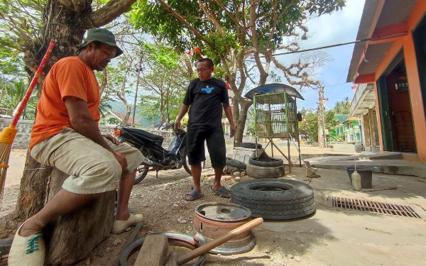 Foto Warga setempat, Alex Harmadi (kaus hitam) yang tinggal tidak jauh dari lokasi tengah berbincang dengan Ketik.co.id soal gerak-gerik pengunjung di bawah pohon sono. (Foto: Al Ahmadi/Ketik.co.id)