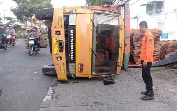 Hindari Sepeda Motor, Truk Muat Kayu Terguling di Raya Sememi