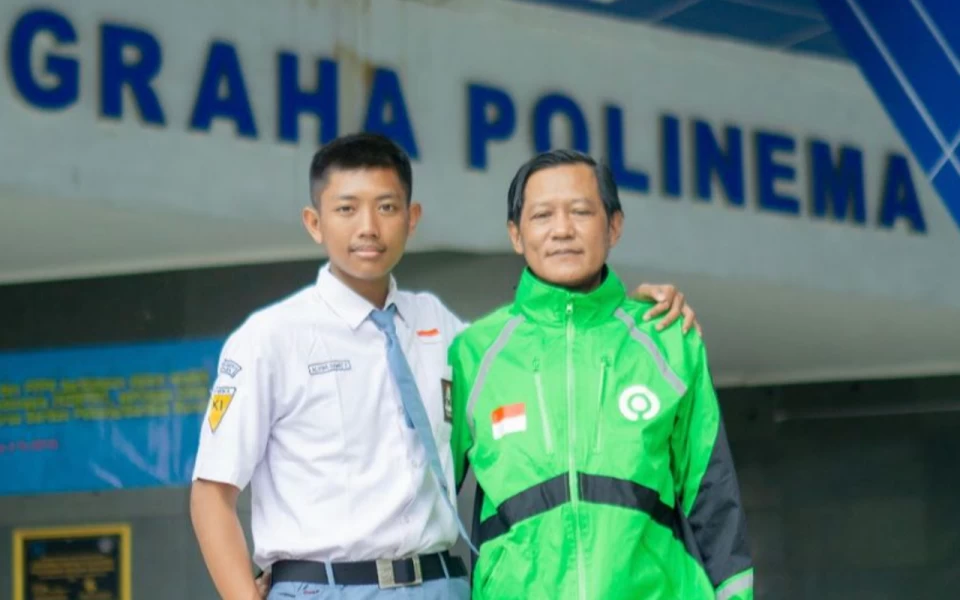 Foto Alvino Damic Yohanda, bersama sang ayah, Yohanes Damic Cahyono, mitra Goride Malang, di depan Graha Polinema. (Foto: dok. Gojek)