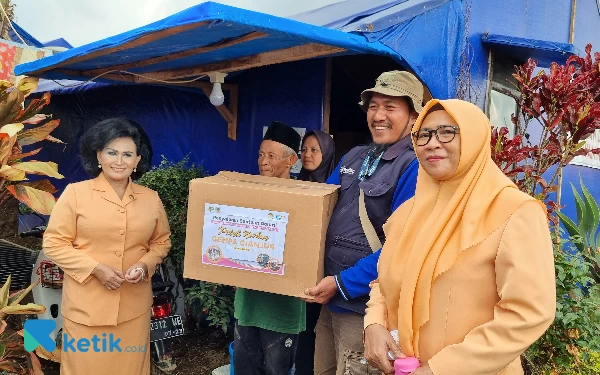 Foto Dewan Pembina IKAWATI ATR/BPN RI Nanny Hadi Tjahjanto menyalurkan bantuan paket sembako kepada korban gempa Cianjur di posko pengungsian.  (Foto: Millah Irodah/Ketik.co.id)