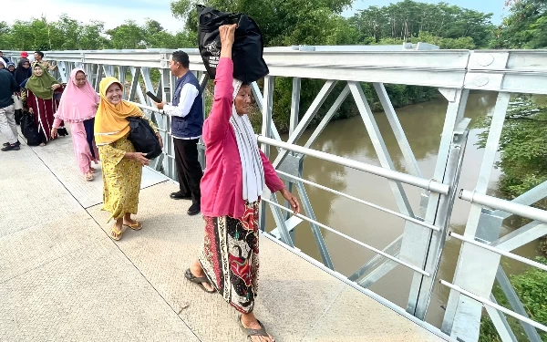 Foto Masyarakat melintasi jembatan Bailey di desa Kregenan Kec. Kraksaan Kab. Probolinggo usai diresmikan Gubernur Jatim Khofifah Indar Parawansa (3/1). (Foto:Humas Pemprov Jatim)